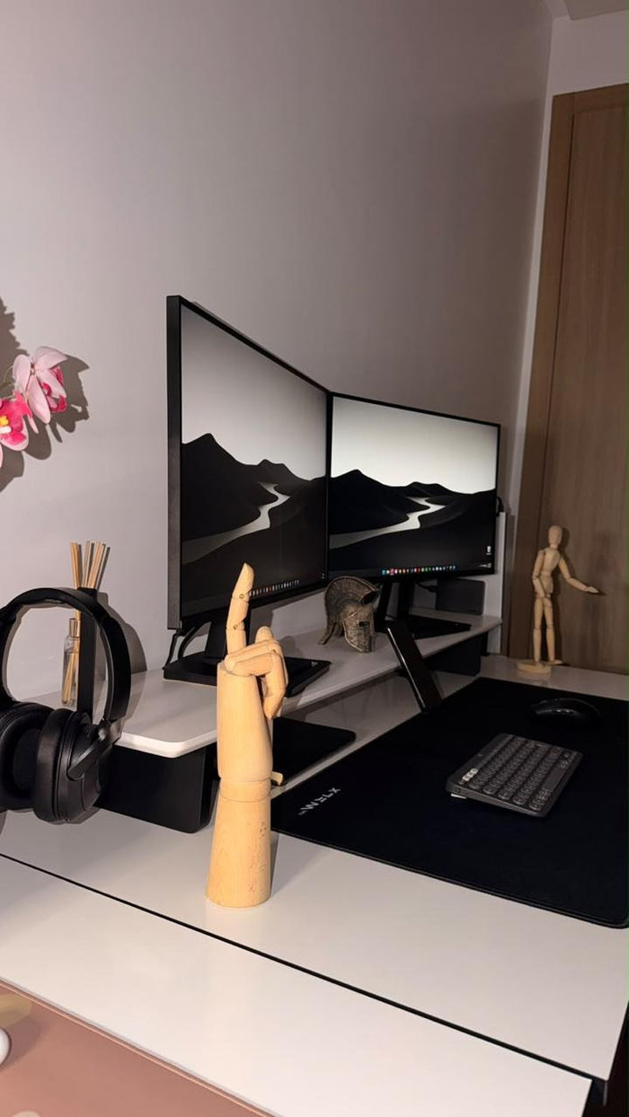 Two monitors on a large matte white desk shelf, side view